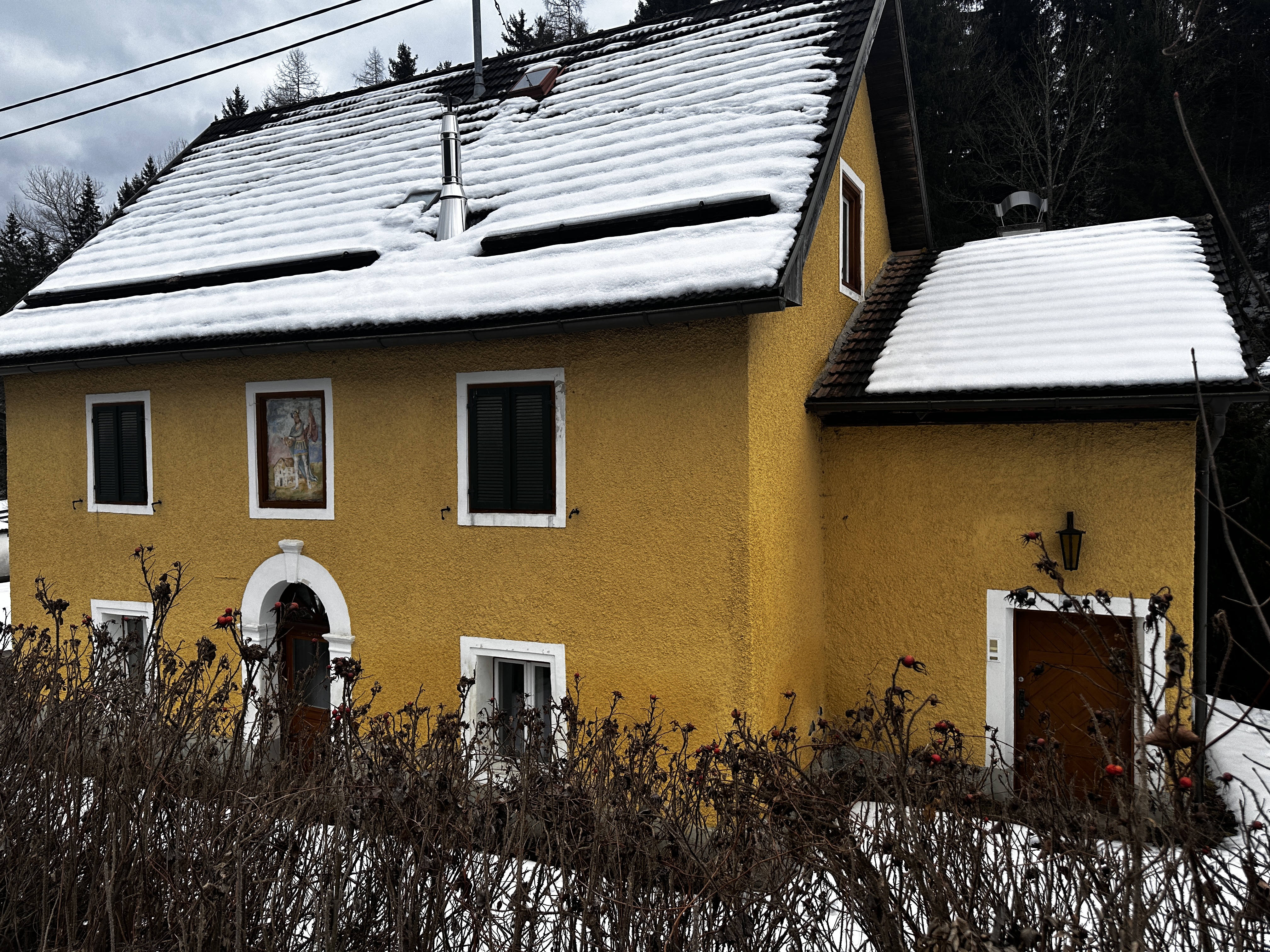 Originalfoto: gelbe Fassade mit dokumentiertem Eingang im Winter.