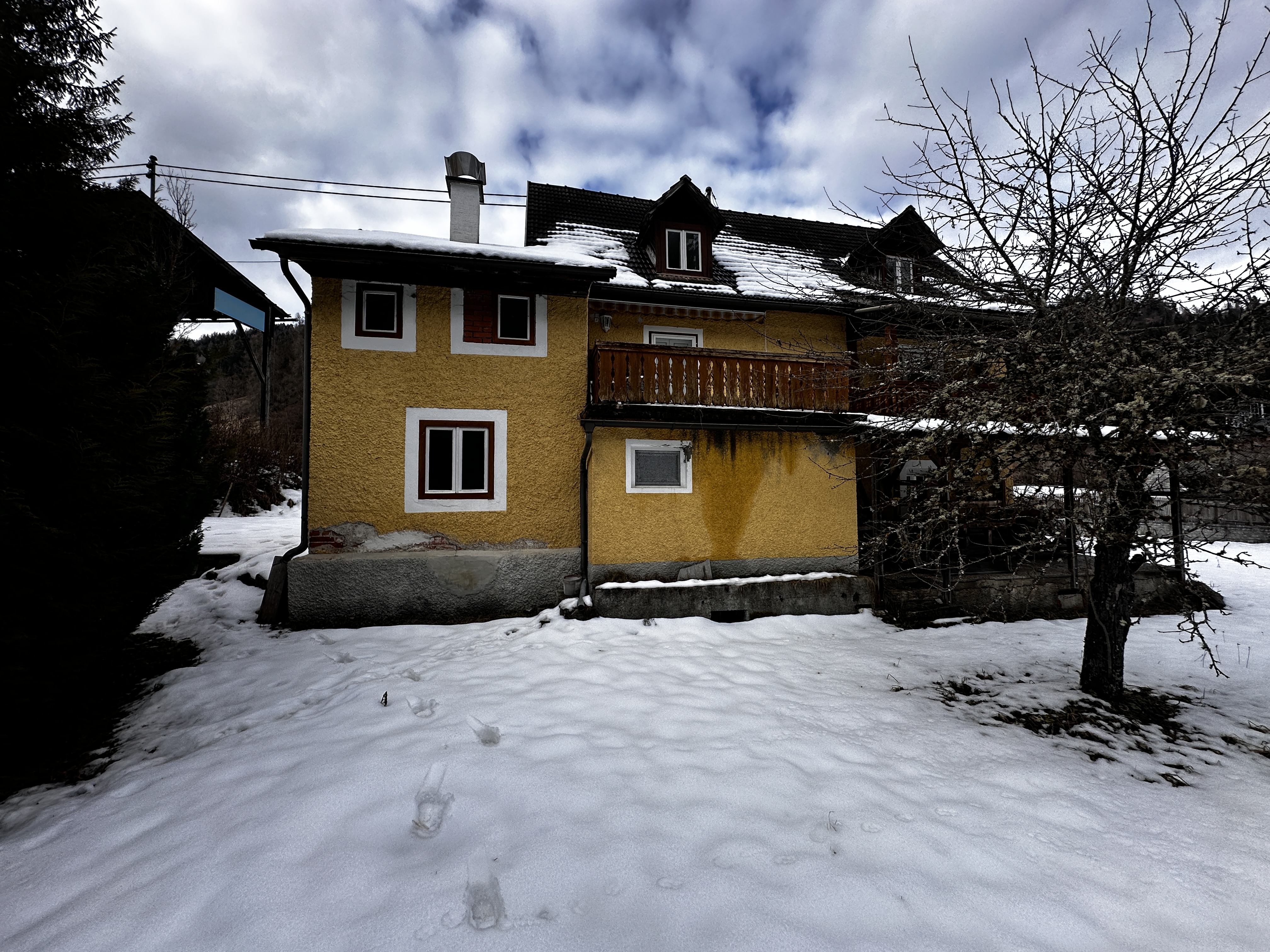 Rück- und Seitenansicht des Hauses mit Balkon im Winter.